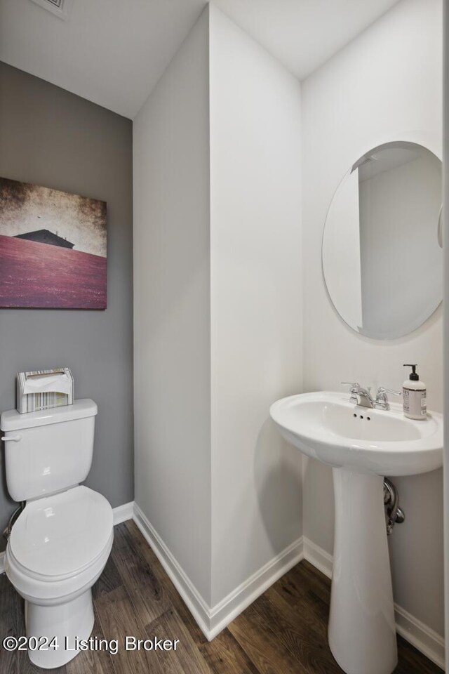 bathroom with hardwood / wood-style floors, toilet, and sink