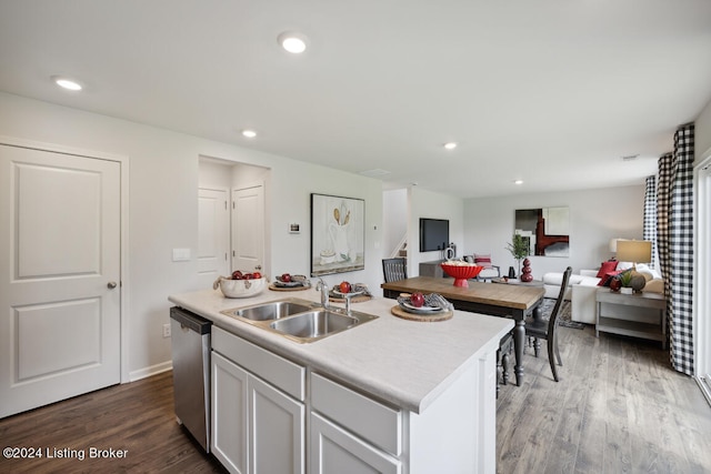 kitchen with white cabinets, sink, hardwood / wood-style flooring, dishwasher, and an island with sink