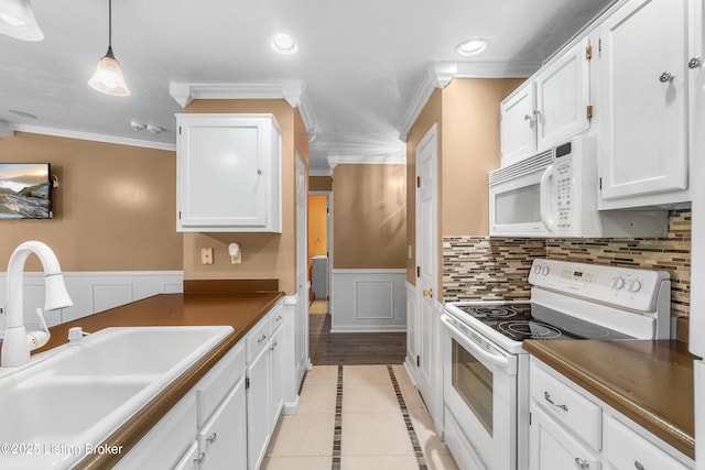 136 Beechtree Ln, Mt Washington, KY 40047 - kitchen with crown molding, white appliances, white cabinets, a sink, and light tile patterned floors