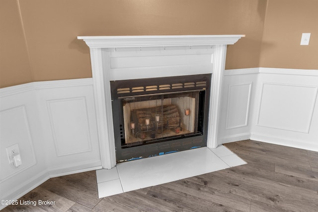 136 Beechtree Ln, Mt Washington, KY 40047 - details featuring a fireplace with flush hearth, a decorative wall, wainscoting, and wood finished floors