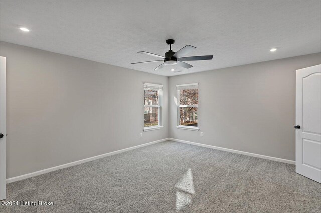 carpeted empty room with a textured ceiling and ceiling fan