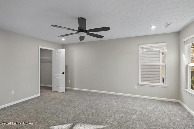 unfurnished bedroom with ceiling fan, a closet, and carpet floors