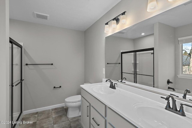 bathroom featuring vanity, toilet, and a shower with shower door