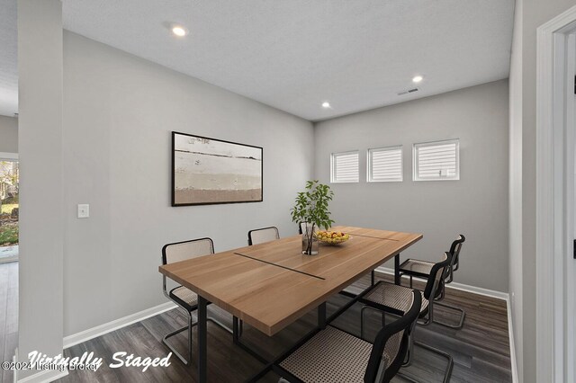 dining room featuring dark hardwood / wood-style flooring and a textured ceiling