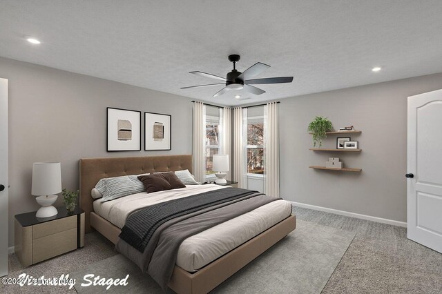 carpeted bedroom featuring ceiling fan and a textured ceiling