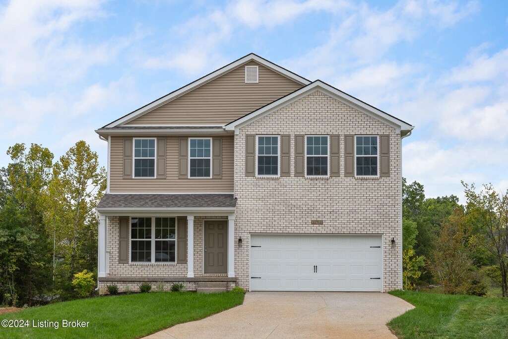 view of front of property featuring a garage and a front lawn