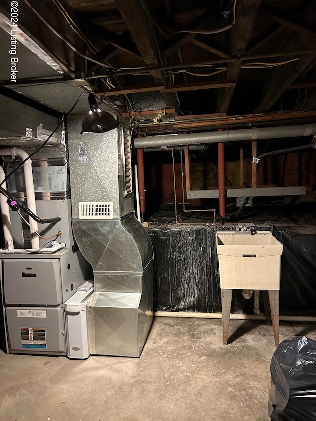 basement featuring heating unit and sink