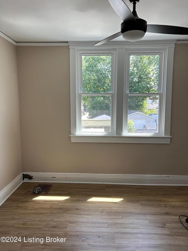 spare room with ceiling fan, plenty of natural light, ornamental molding, and hardwood / wood-style flooring