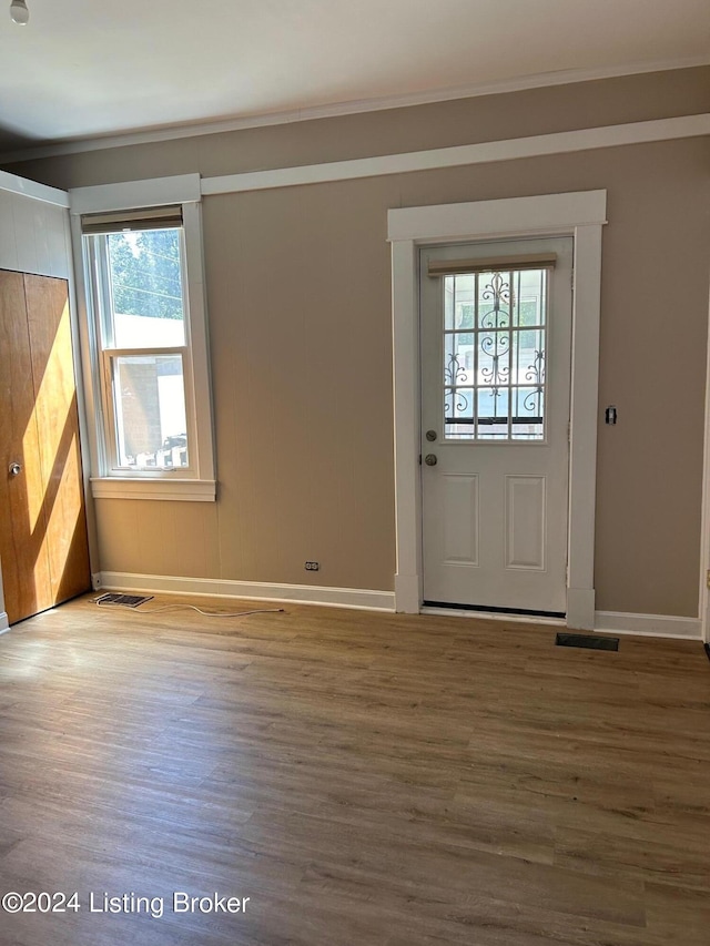 foyer featuring plenty of natural light, wood-type flooring, and ornamental molding