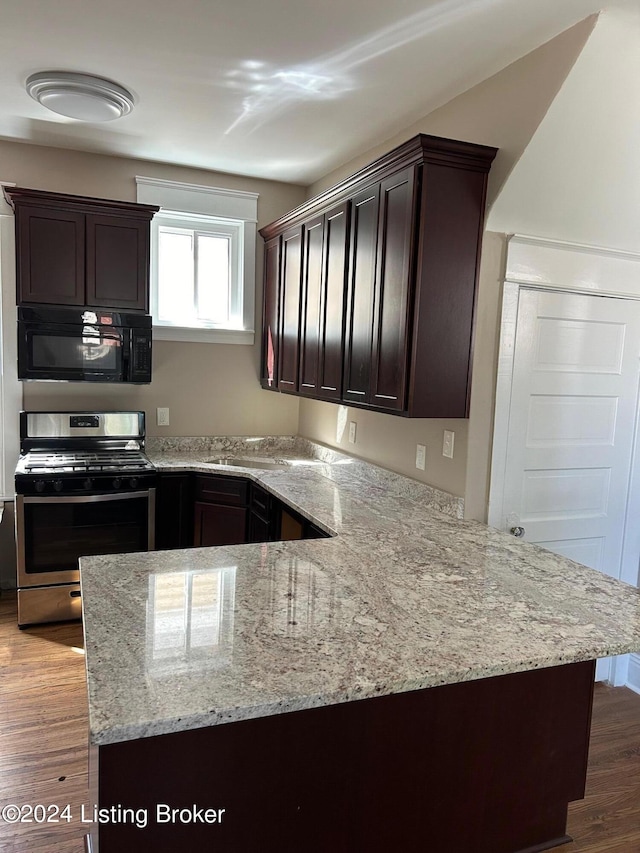 kitchen featuring dark brown cabinets, dark hardwood / wood-style flooring, stainless steel range with gas cooktop, and kitchen peninsula