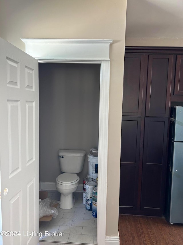 bathroom featuring toilet and wood-type flooring