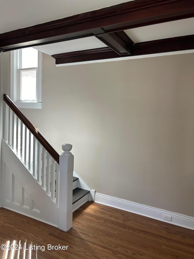 stairway with hardwood / wood-style floors and beam ceiling