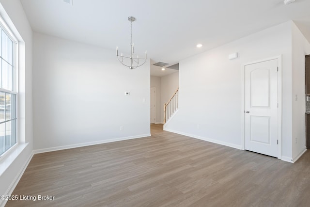 unfurnished room featuring light hardwood / wood-style flooring and a chandelier