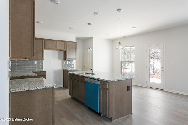 kitchen with dishwasher, an island with sink, hanging light fixtures, and sink