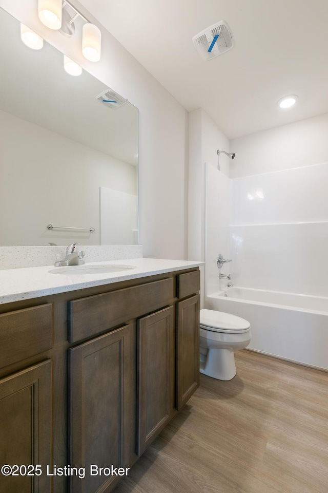 full bathroom with bathtub / shower combination, hardwood / wood-style floors, vanity, and toilet