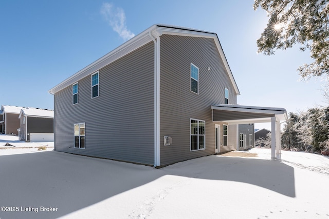 view of snow covered back of property