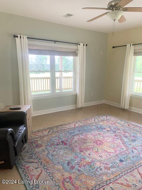 tiled spare room with ceiling fan