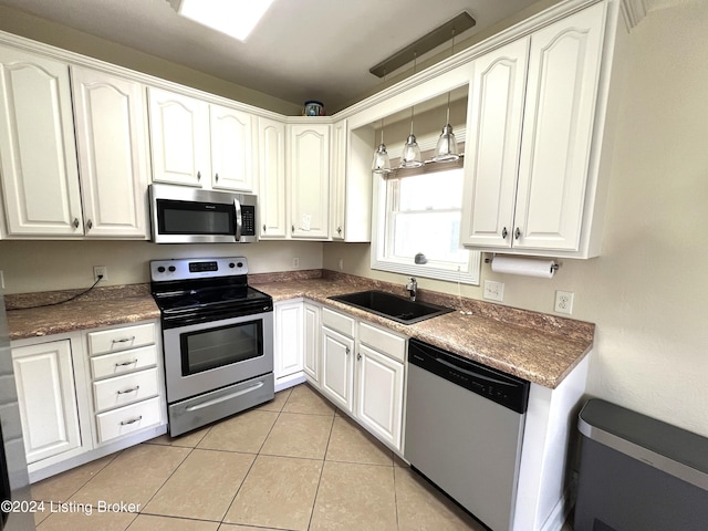 kitchen with pendant lighting, sink, white cabinetry, and appliances with stainless steel finishes