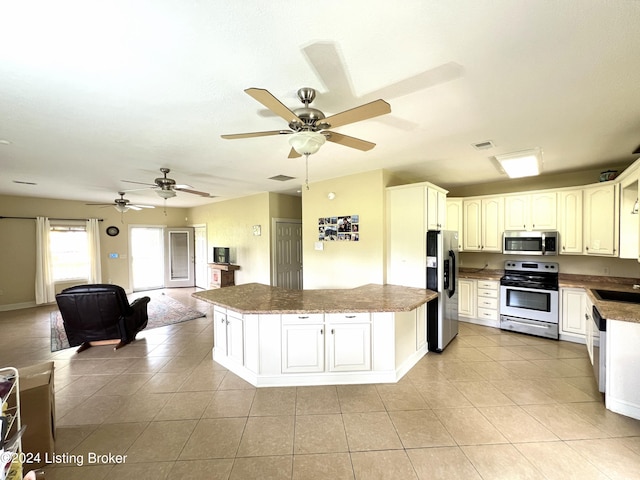 kitchen with light tile patterned flooring, stainless steel appliances, sink, and white cabinets