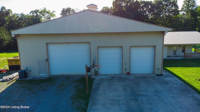 garage featuring central AC and a lawn