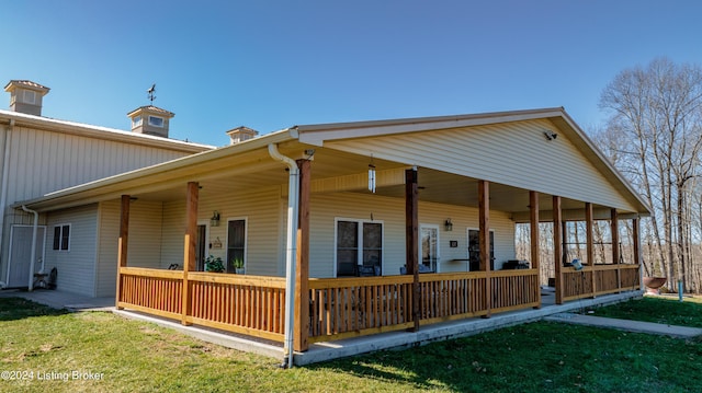 rear view of property with a yard and covered porch