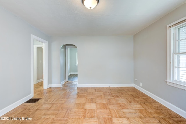 spare room featuring light parquet floors and plenty of natural light