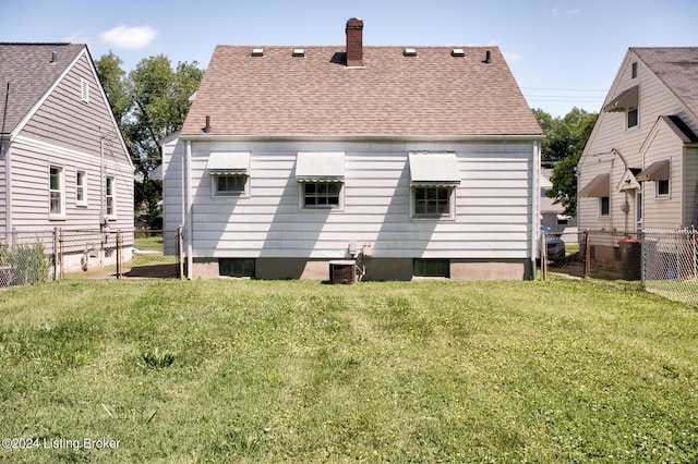 back of property with a lawn and central AC