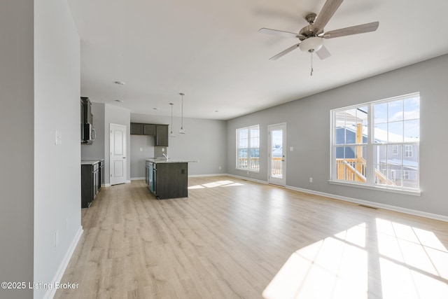 unfurnished living room with ceiling fan and light wood-type flooring