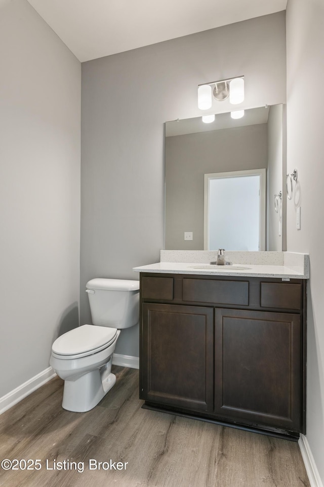 bathroom featuring hardwood / wood-style flooring, vanity, and toilet