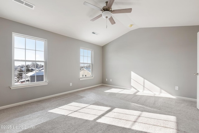 empty room with ceiling fan, light colored carpet, and vaulted ceiling