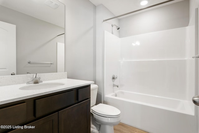 full bathroom with washtub / shower combination, hardwood / wood-style floors, vanity, and toilet