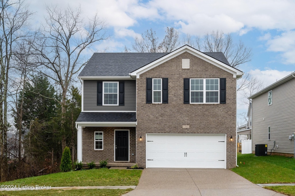 view of front of house with central AC, a garage, and a front lawn