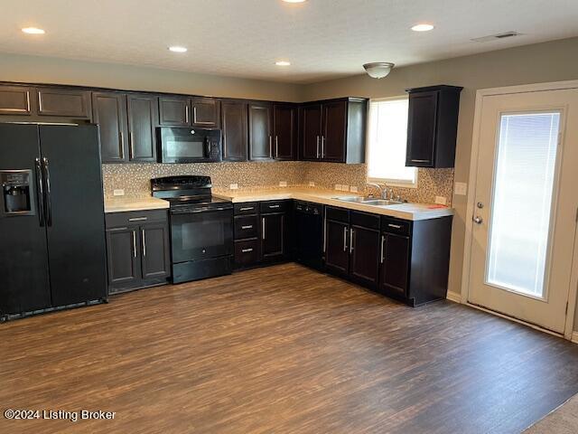 kitchen featuring sink, backsplash, dark hardwood / wood-style floors, and black appliances