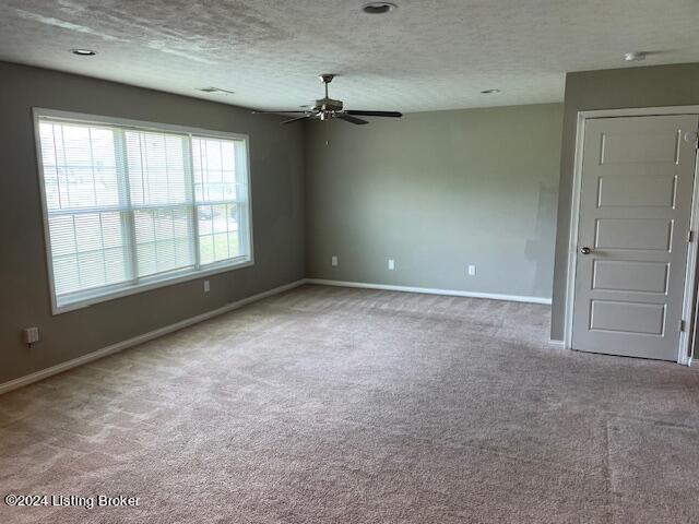 spare room featuring ceiling fan, carpet floors, and a textured ceiling