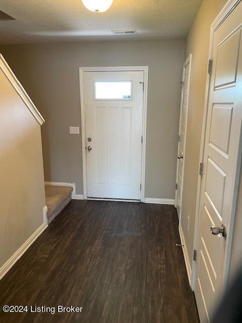 entrance foyer with dark wood-type flooring and a textured ceiling