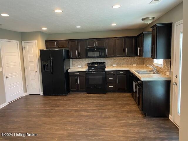 kitchen with tasteful backsplash, sink, dark wood-type flooring, black appliances, and dark brown cabinets