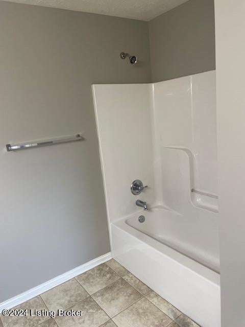 bathroom featuring tile patterned flooring, a textured ceiling, and  shower combination