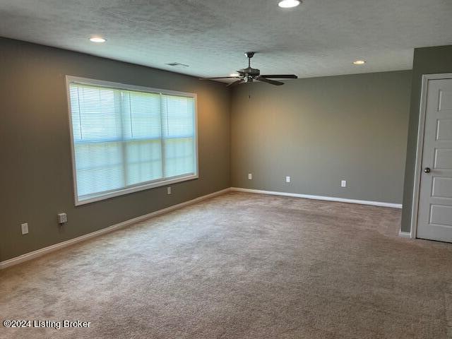 spare room with ceiling fan, a textured ceiling, and carpet flooring