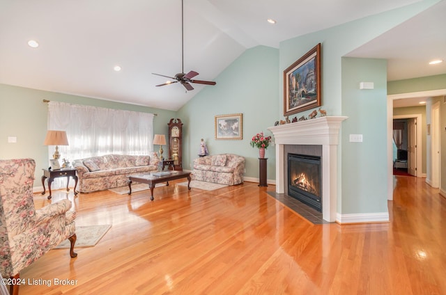 living room featuring hardwood / wood-style flooring, ceiling fan, and vaulted ceiling