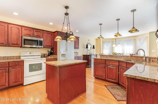 kitchen featuring white electric range, sink, a center island, hanging light fixtures, and light hardwood / wood-style floors