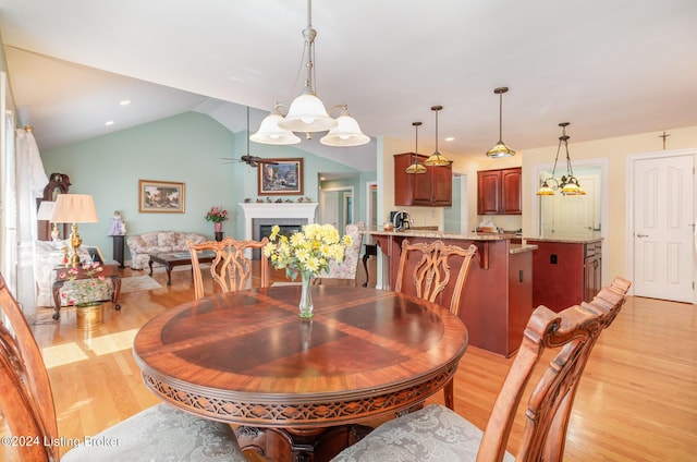 dining area with vaulted ceiling, ceiling fan, and light wood-type flooring