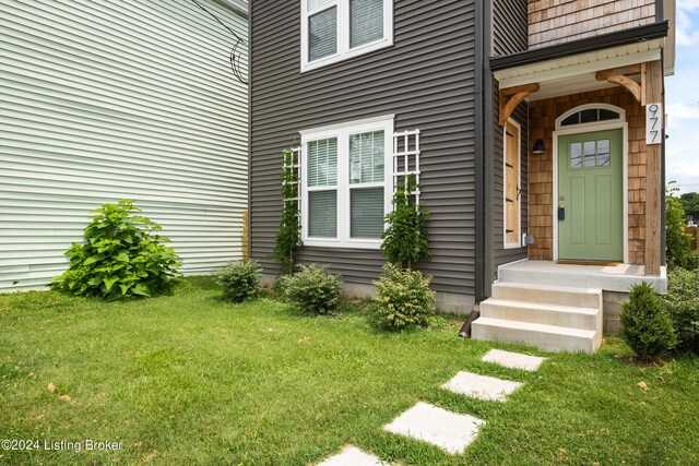 entrance to property with a lawn