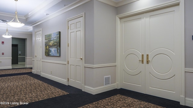 interior space with dark colored carpet, a raised ceiling, and ornamental molding