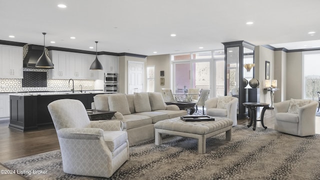 living room featuring dark hardwood / wood-style flooring, plenty of natural light, and ornamental molding