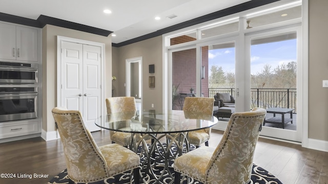 dining space featuring crown molding and dark wood-type flooring