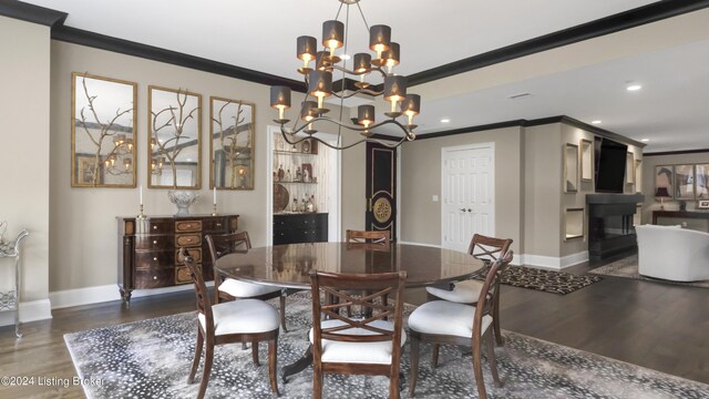 dining space with ornamental molding, dark wood-type flooring, and a notable chandelier