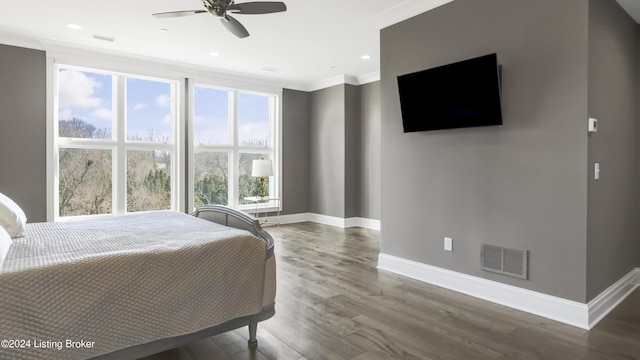 bedroom with multiple windows, ceiling fan, crown molding, and hardwood / wood-style flooring