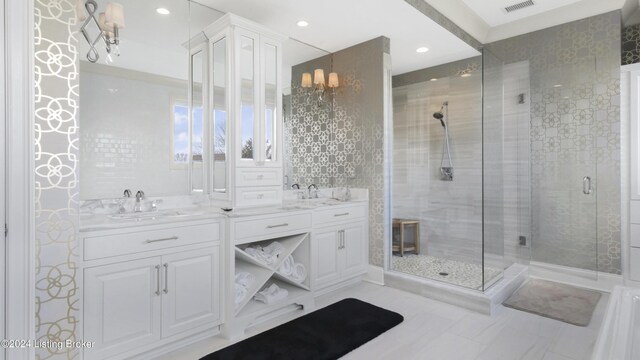 bathroom featuring vanity, an inviting chandelier, and a shower with door