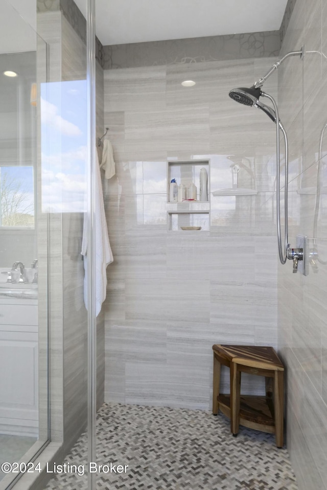 bathroom with a shower with door and tile walls