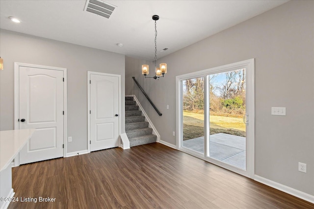 spare room featuring dark hardwood / wood-style flooring and a notable chandelier